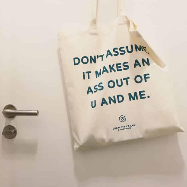 Katoenen tas in gebruik. Don't Assume. It Makes An Ass Out Of U And Me.